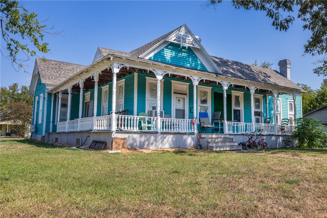 610 West Davis Street Hearne, TX 77859 - Photo 4 of 27 View of front of property featuring a large porch, a front yard, a chimney, and a shingled roof