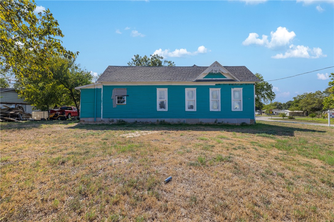 610 West Davis Street Hearne, TX 77859 - Photo 5 of 27 View of side of home featuring a lawn and roof with shingles