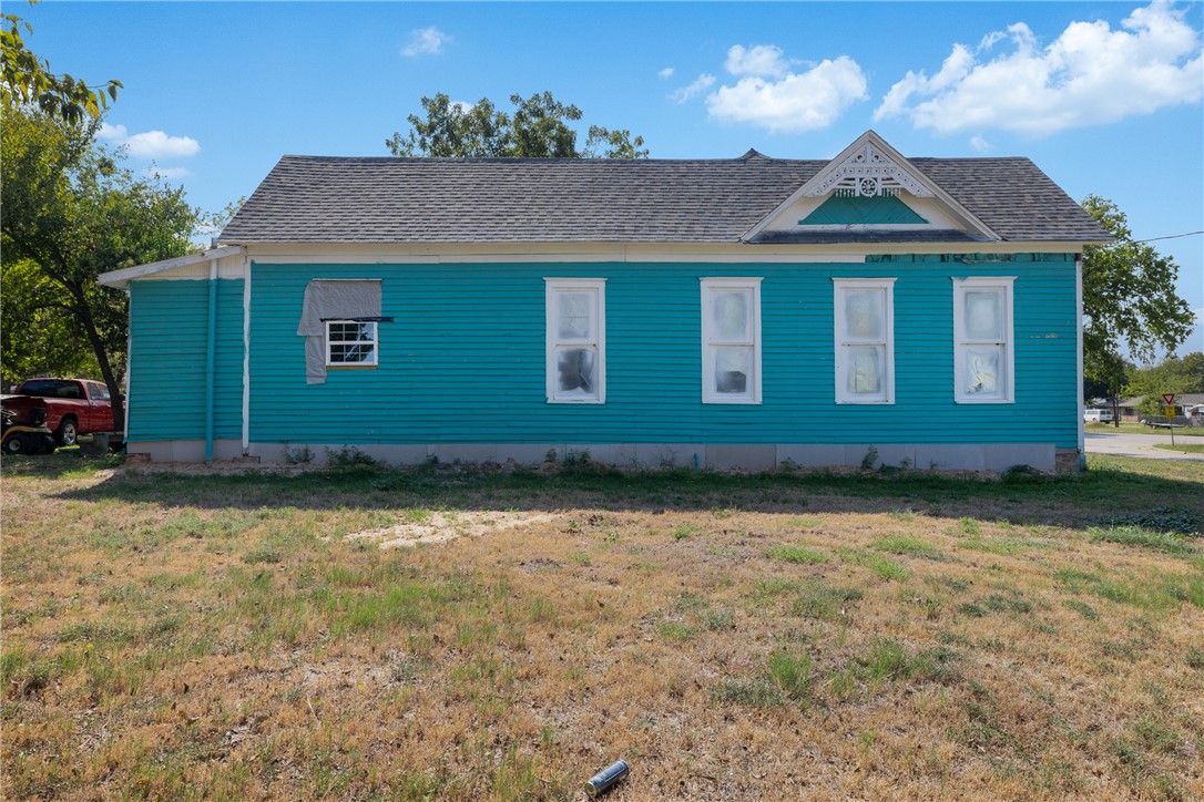 610 West Davis Street Hearne, TX 77859 - Photo 6 of 27 View of property exterior featuring a shingled roof and a yard