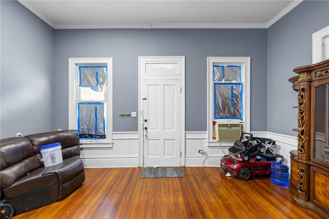 610 West Davis Street Hearne, TX 77859 - Photo 9 of 27 Entryway featuring ornamental molding, hardwood / wood-style floors, and a wainscoted wall