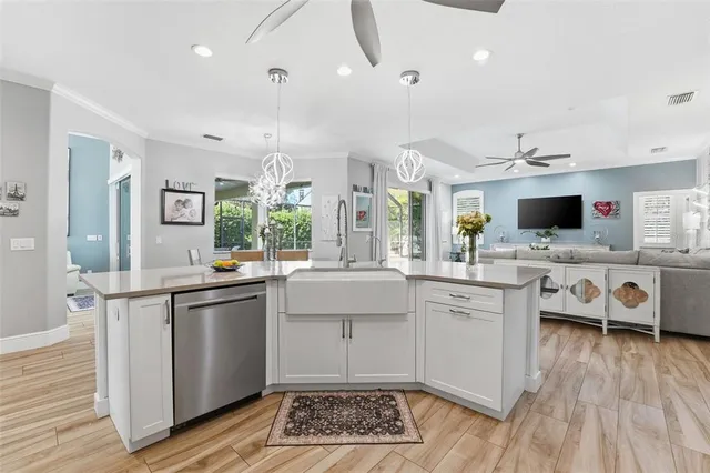 a kitchen with stainless steel appliances a stove a sink dishwasher a oven with white cabinets and wooden floor