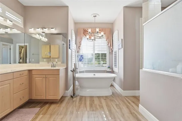 a spacious bathroom with a double vanity sink a large mirror and a shower