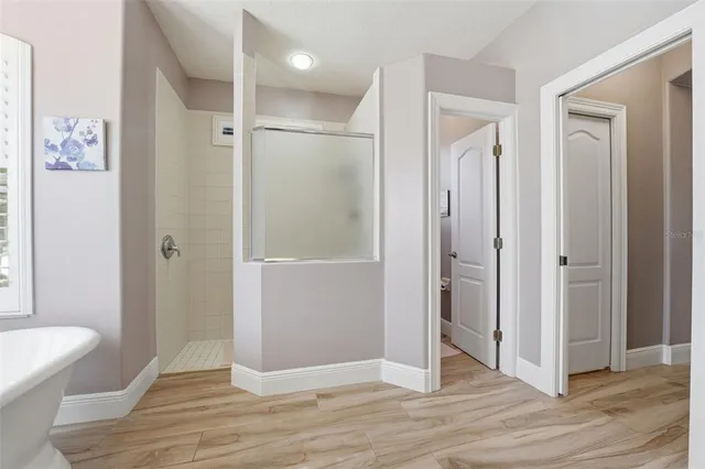 a view of a bathroom with wooden floor mirror and shower