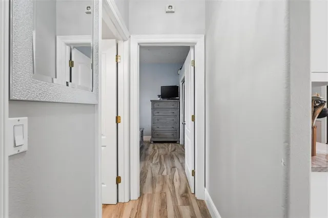 a view of a hallway with wooden floor and closet