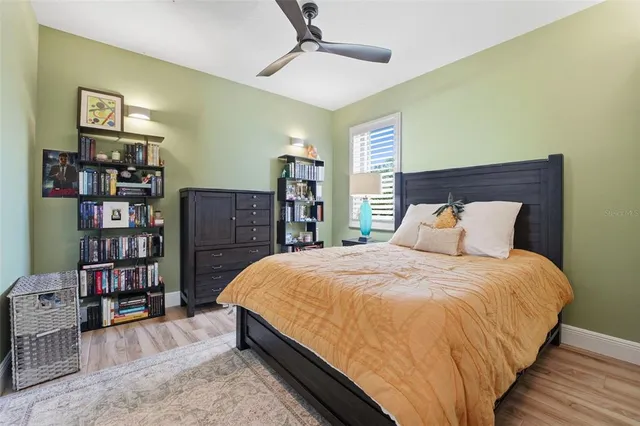 a bed sitting in a bedroom next to a book shelf