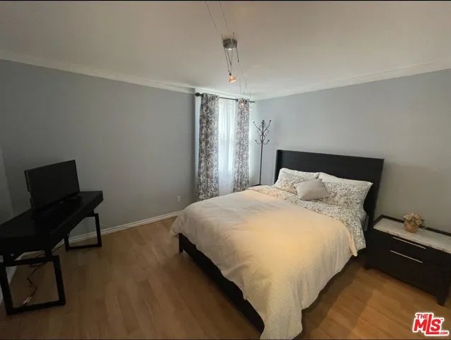 a bedroom with a bed next to a window