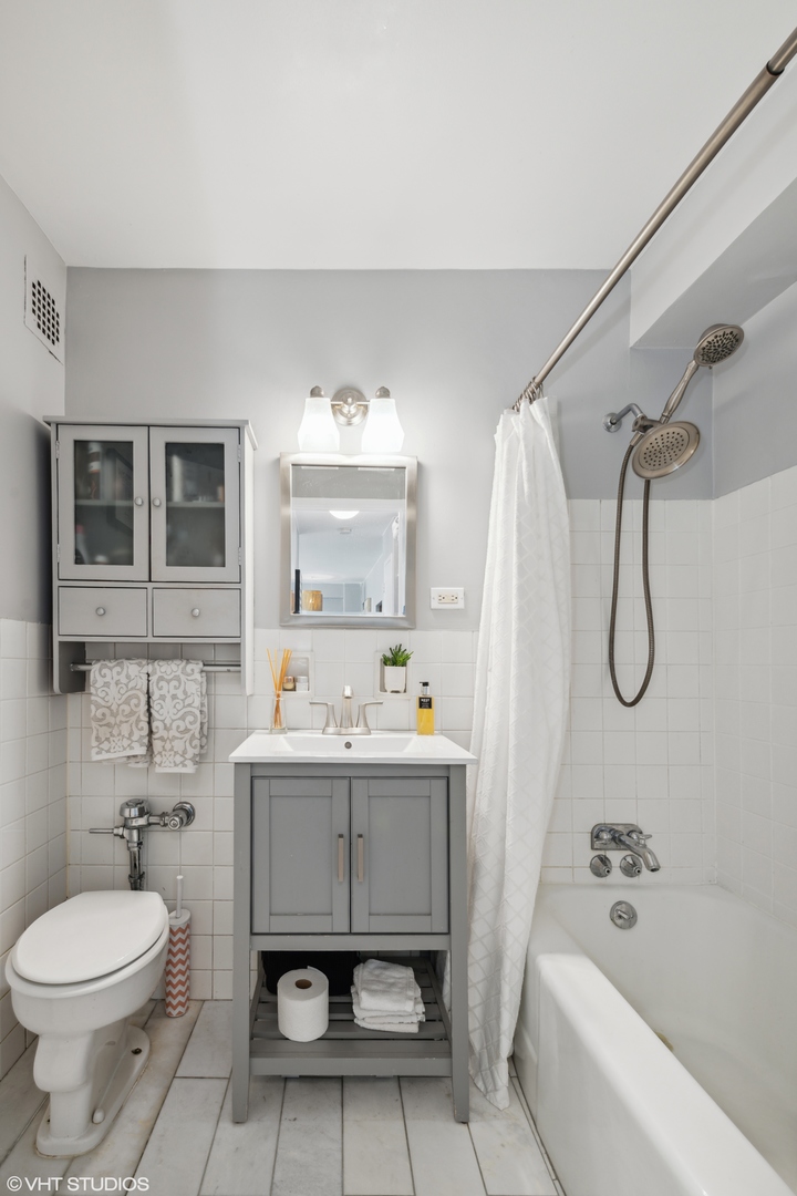 2909 North Sheridan Road, Unit 1711 Chicago, IL 60657 - Photo 9 of 14 a bathroom with a sink toilet and shower