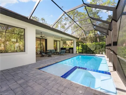 a living room with furniture a flat screen tv and a large window