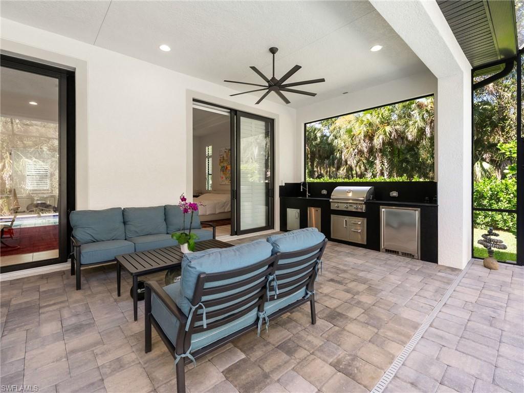 4199 11th Avenue Southwest Naples, FL 34116 - Photo 19 of 36 a living room with furniture a flat screen tv and a large window