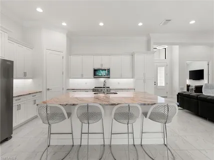a kitchen with granite countertop cabinets and chairs