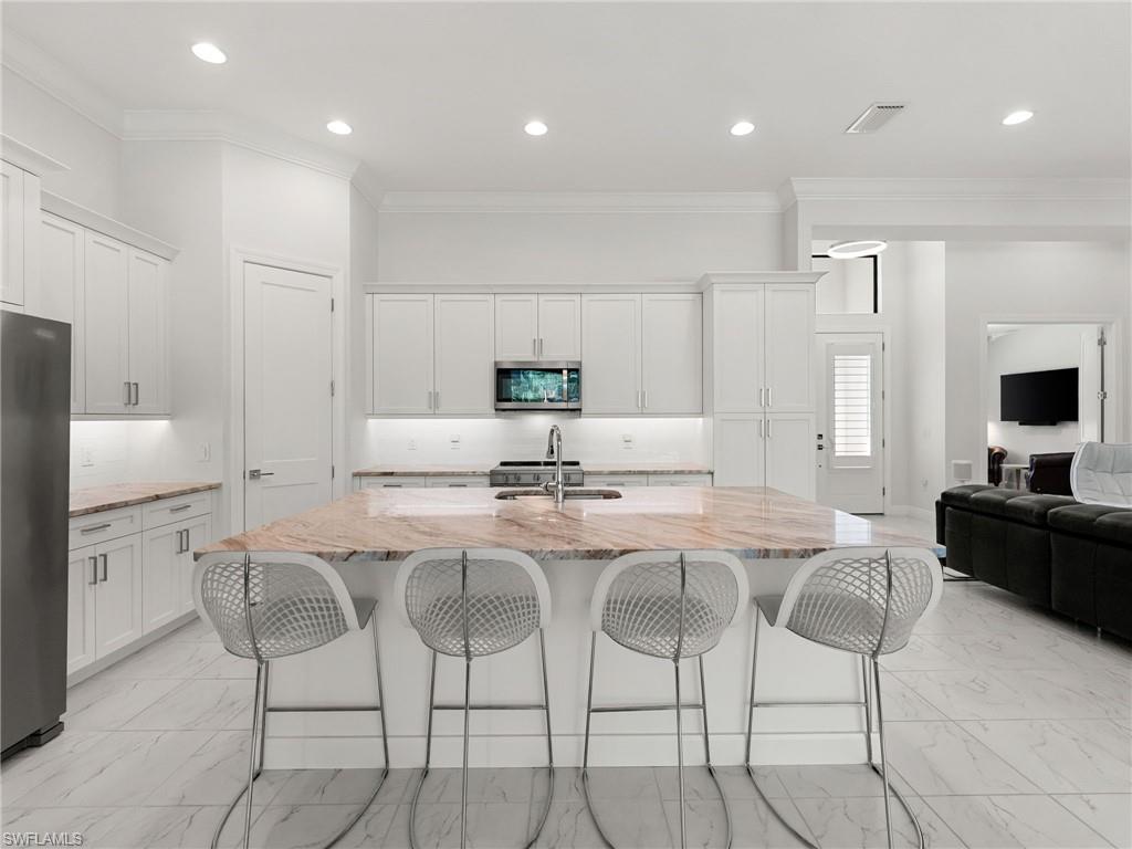 4199 11th Avenue Southwest Naples, FL 34116 - Photo 6 of 36 a kitchen with granite countertop cabinets and chairs