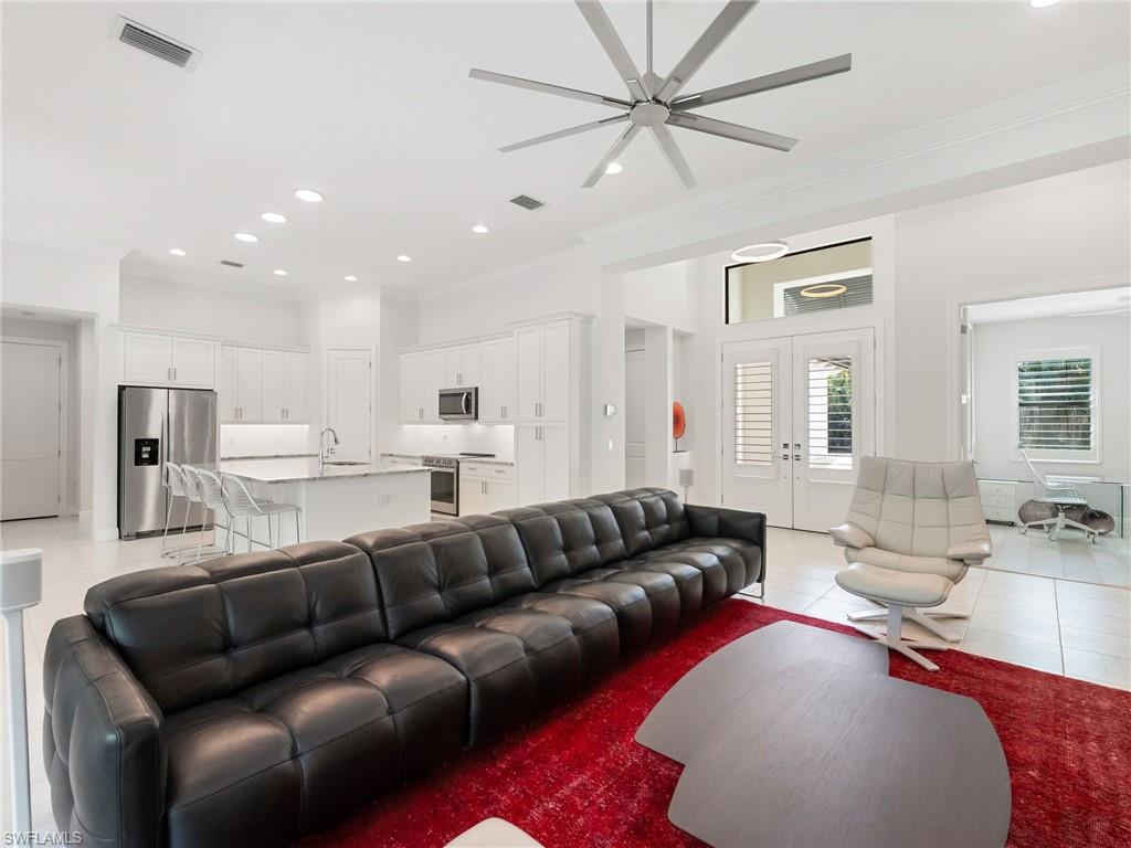 4199 11th Avenue Southwest Naples, FL 34116 - Photo 10 of 36 a living room with furniture and a chandelier