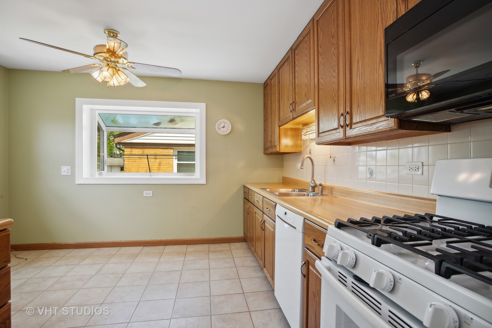556 Pinehurst Drive Des Plaines, IL 60016 - Photo 6 of 18 a kitchen with a stove a sink and a microwave