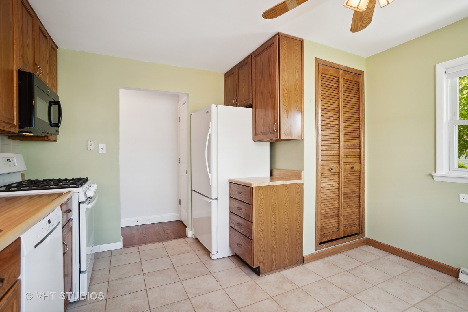 556 Pinehurst Drive Des Plaines, IL 60016 - Photo 7 of 18 a kitchen with a refrigerator a stove top oven and cabinets