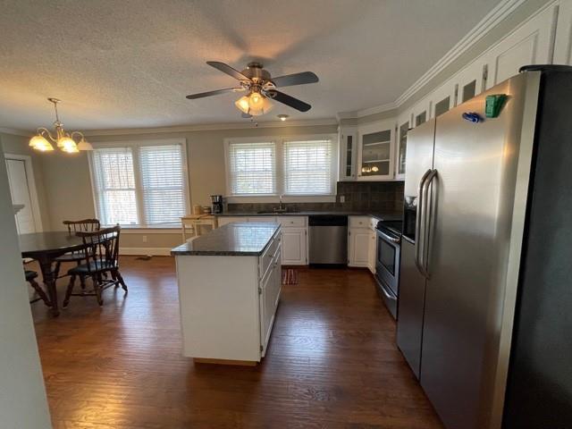 727 Lattimore Road Rutherfordton, NC 28139 - Photo 5 of 48 a kitchen with stainless steel appliances granite countertop a refrigerator a sink a stove and a dining table with wooden floor