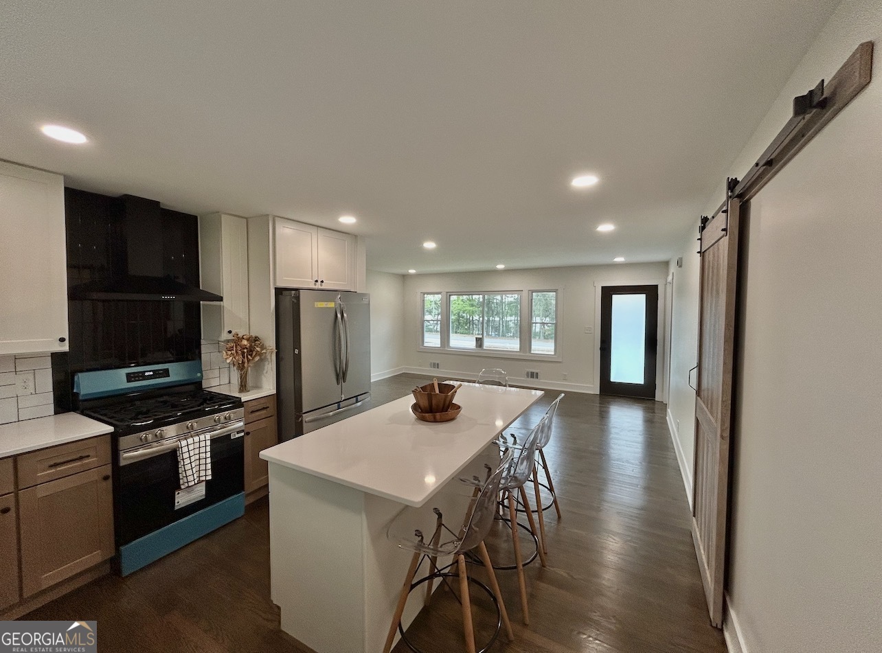 1742 Constitution Road Southeast Atlanta, GA 30316 - Photo 7 of 32 a kitchen with stainless steel appliances a dining table chairs stove refrigerator and microwave