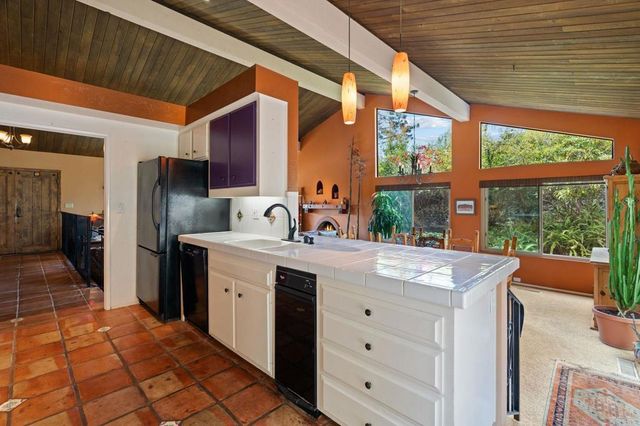 a kitchen with a sink appliances cabinets and a counter top space