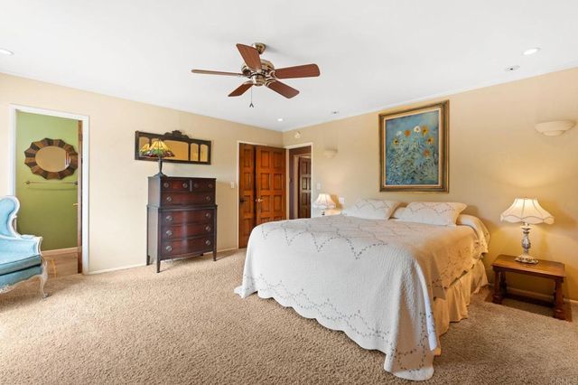 a spacious bedroom with a bed and a chandelier