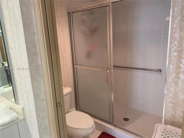 a bathroom with a shower a toilet and a sink