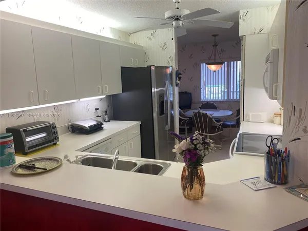 a kitchen with a refrigerator a sink and cabinets