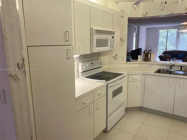 a kitchen with white cabinets and white appliances