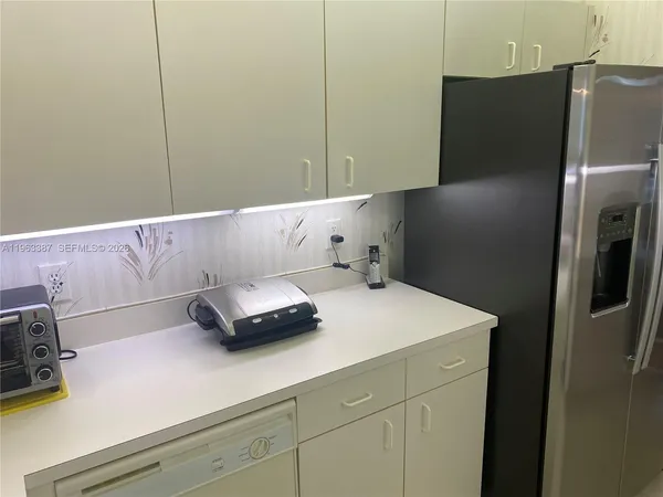 a kitchen with a refrigerator and cabinets