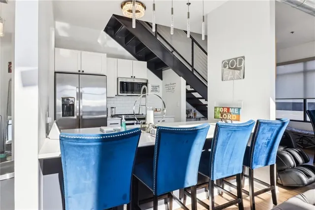 a kitchen with stainless steel appliances a table chairs and a refrigerator