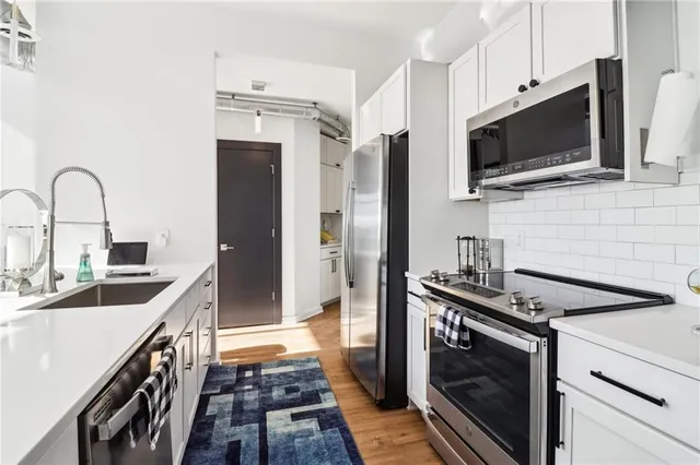 a kitchen with stainless steel appliances a stove microwave and sink