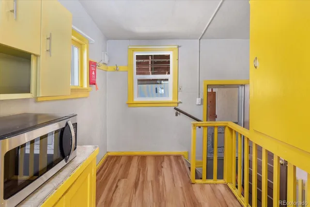 a view of a hallway with wooden floor and a flat screen tv