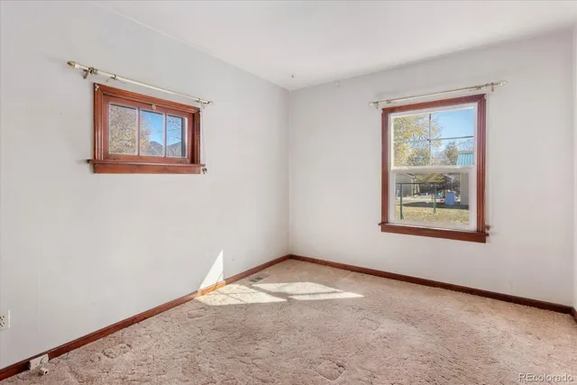 an empty room with closet and a hallway