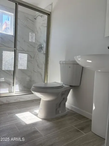 a white toilet sitting next to a shower