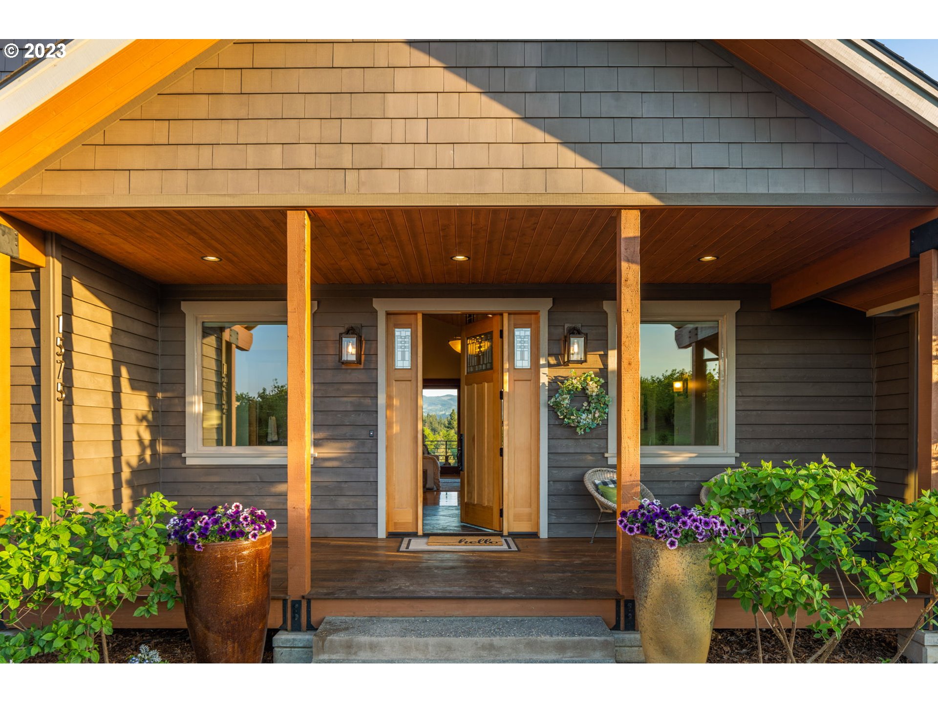 1575 Nunamaker Road Hood River, OR 97031 - Photo 3 of 48 a front view of a house with a large window and potted plants
