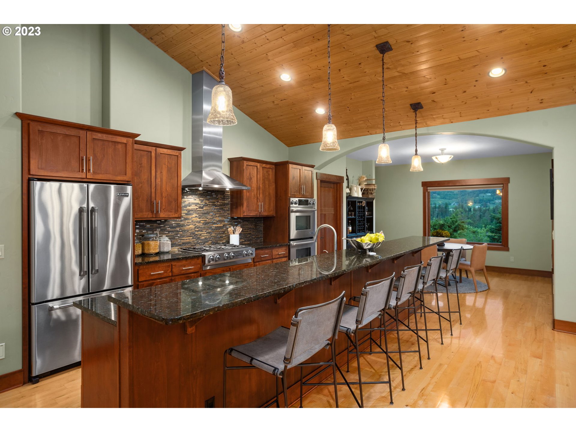 1575 Nunamaker Road Hood River, OR 97031 - Photo 10 of 48 a kitchen with stainless steel appliances granite countertop a refrigerator a sink a dining table and chairs with wooden floor