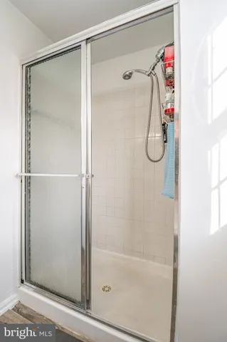 a bathroom with a toilet a sink a window and shower