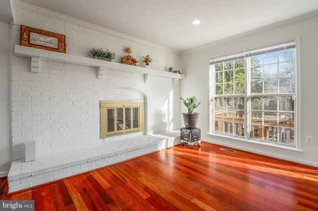 a view of empty room with window and wooden floor