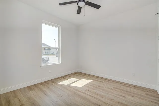 a view of an empty room with wooden floor