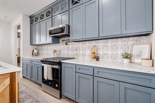 a kitchen with stainless steel appliances granite countertop a sink stove and microwave
