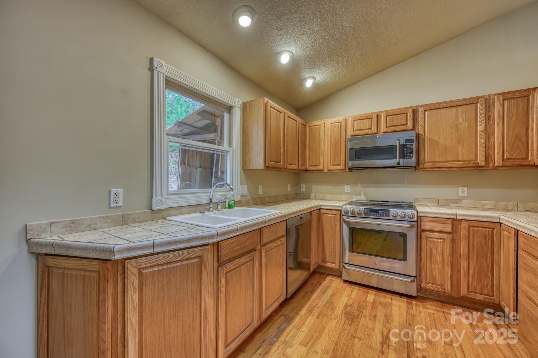534 Parson Branch Road Green Mountain, NC 28740 - Photo 10 of 47 a kitchen with stainless steel appliances granite countertop a sink stove and microwave