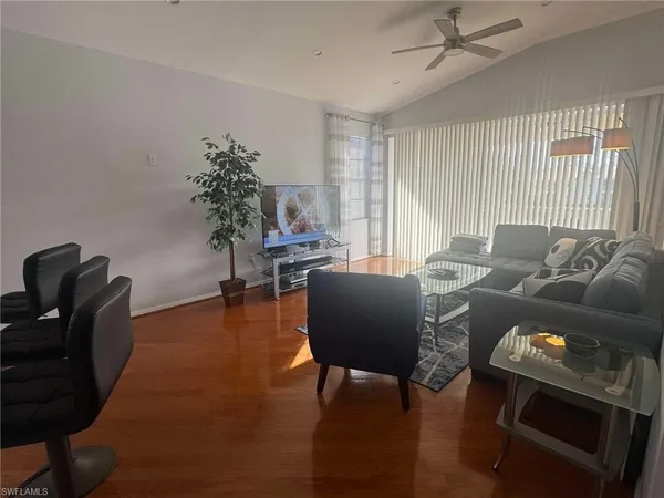 a living room with furniture a rug and a lamp