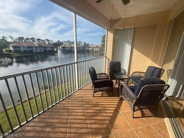 a balcony with wooden floor table and chairs
