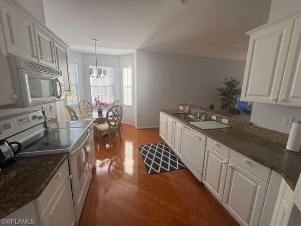 a kitchen with stainless steel appliances granite countertop a sink a refrigerator and a stove