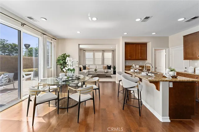 a view of a a dining room with furniture window and wooden floor