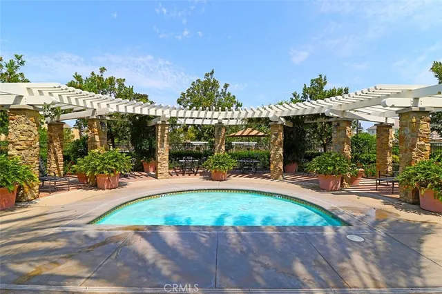 a view of a lake with a bench and trees in the background