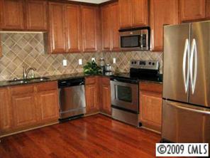 5699 Stafford Road, Unit 72 Charlotte, NC 28215 - Photo 3 of 8 a kitchen with granite countertop wooden cabinets and stainless steel appliances