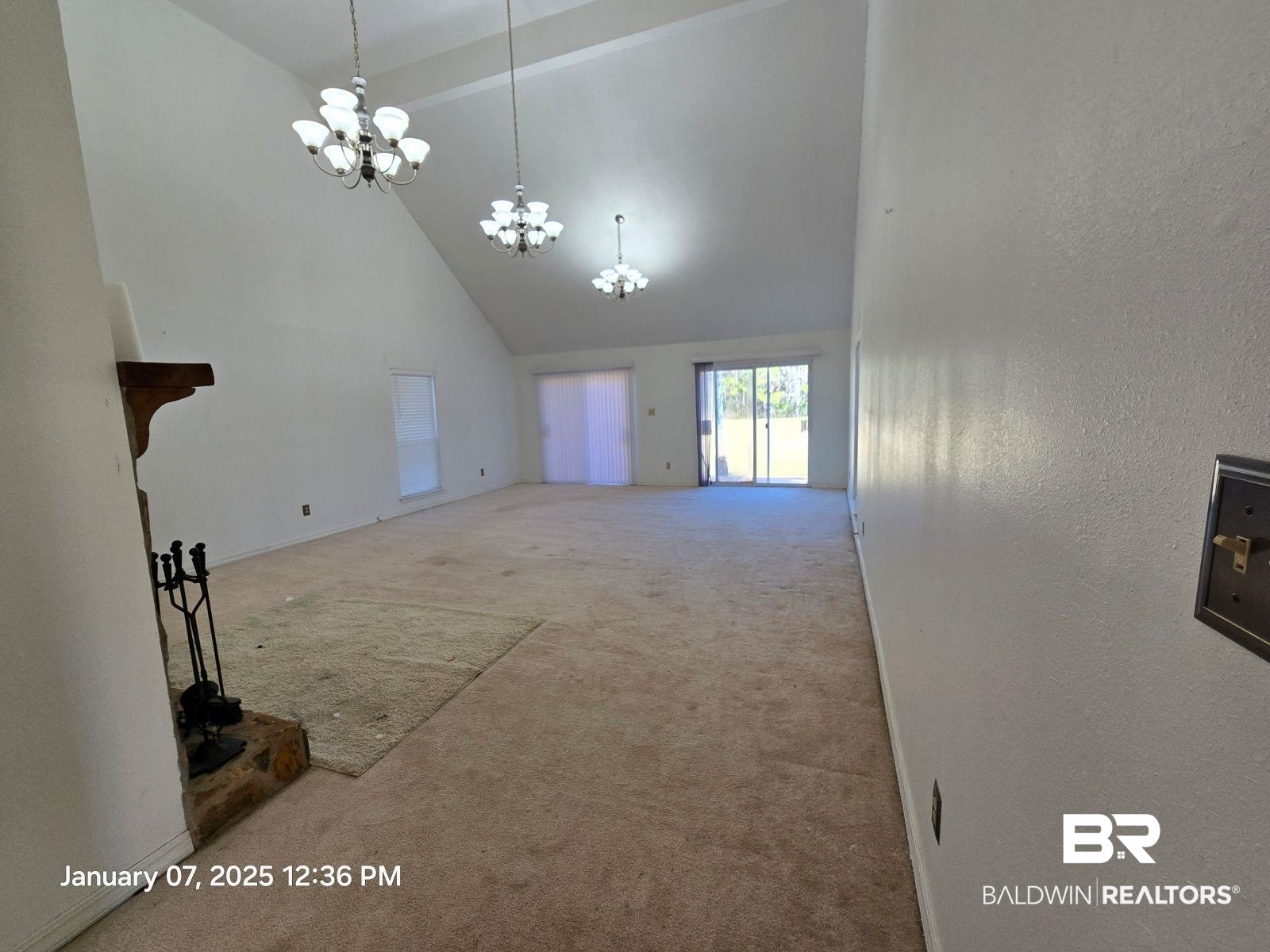 154 Byrd Road Monroeville, AL 36460 - Photo 6 of 26 Unfurnished living room with high vaulted ceiling, a chandelier, and carpet