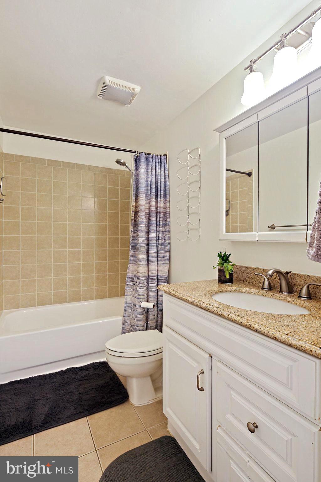 5033 Three Kings Lane Columbia, MD 21044 - Photo 22 of 37 a bathroom with a granite countertop sink a toilet a mirror a bathtub and shower