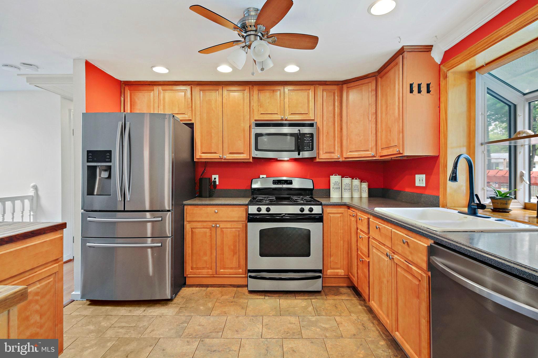 5033 Three Kings Lane Columbia, MD 21044 - Photo 10 of 37 a kitchen with stainless steel appliances kitchen island granite countertop a refrigerator and a stove top oven