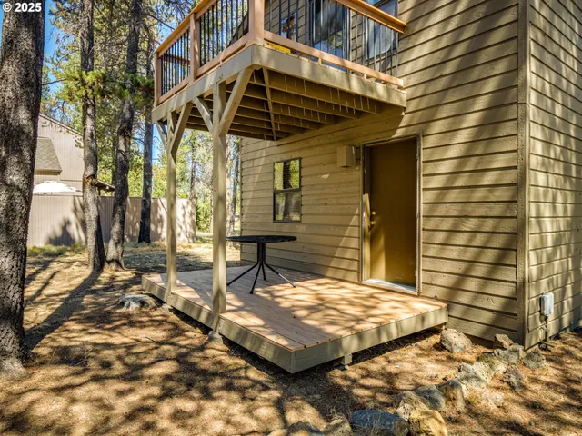 a living room with furniture large windows and wooden floor