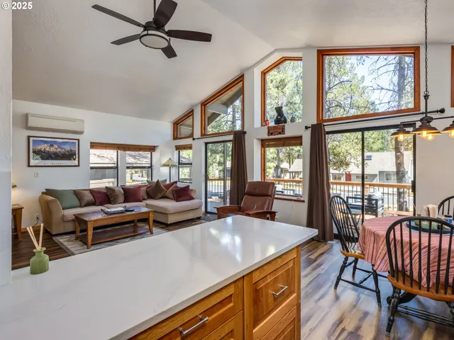 a living room with furniture large window and a wooden floor