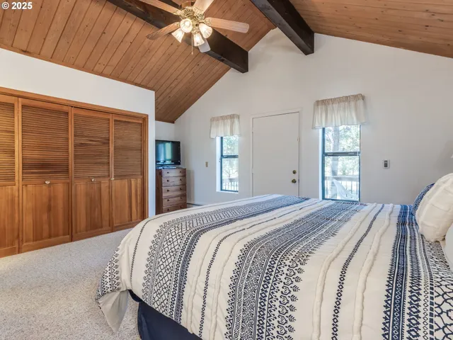 a spacious bedroom with a bed and a chandelier